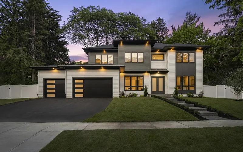 Clopay Modern Steel dark garage doors on a contemporary two-story home at dusk